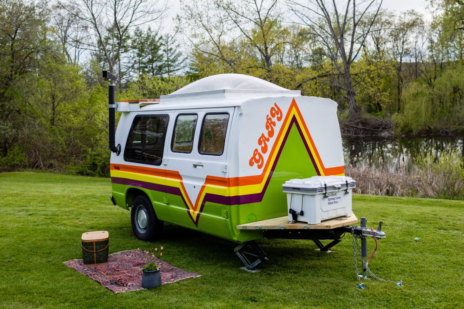 Welcome to Glamp a truckin freen color on the grass with trees in the background